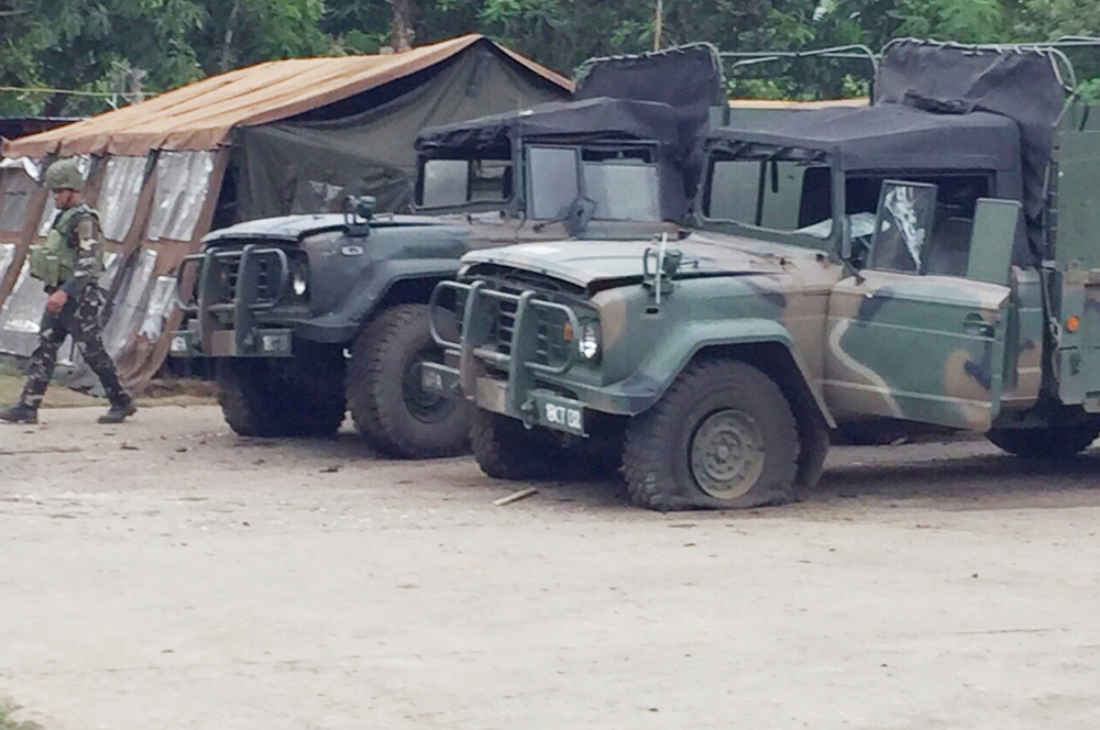 A Philippine soldier walks past military vehicles damaged in a suicide attack at a military camp in Jolo, southern Philippines, June 28, 2019. (Photo: AP)