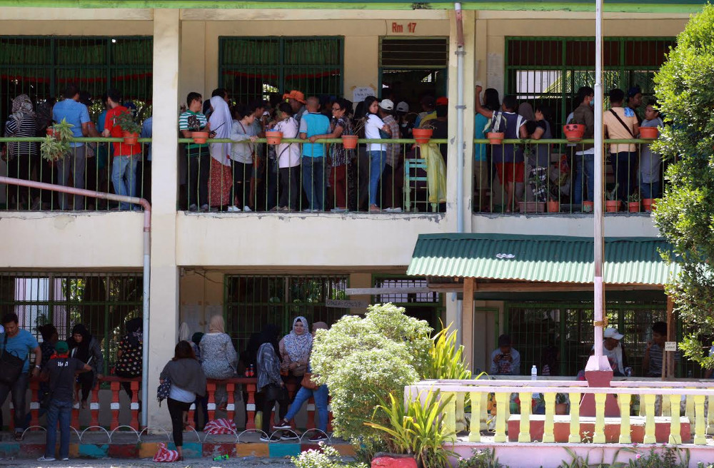 Voters line up to cast their ballots in a referendum to ratify a law that would give Muslims autonomy in the southern Philippines, at a polling center at an elementary school in Cotabato City, Jan. 21, 2019. [Jeoffrey Maitem/BenarNews]