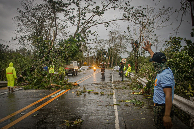 First responders and police officers clear debris from Typhoon Vongfong off a highway in Eastern Samar province, central Philippines, May 14, 2020. [Alren Beronio/BenarNews]