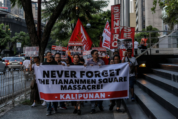 Demonstrators carry signs as they march past the Chinese Embassy in Manila’s financial district to mark the 30th anniversary of the Tiananmen Square massacre, June 4, 2019. (Basilio Sepe/BenarNews)