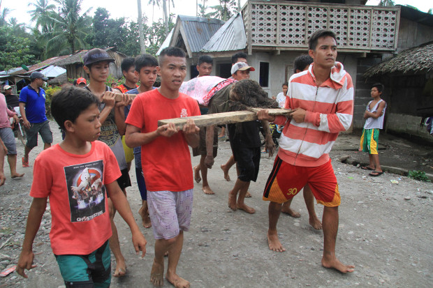 Locals in Salvador town, Lanao del Norte, carry a person who died during Tropical Storm Tembin Dec. 22, 2017. 