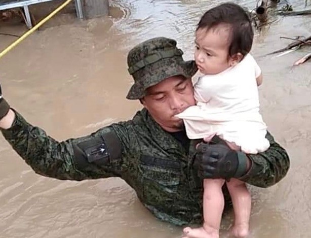 A Philippine soldier rescues a baby in the town of Libmanan, Camarines Sur province, Nov. 12, 2020. [Handout Armed Forces of the Philippines]