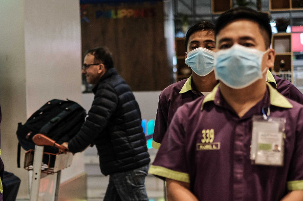 Personnel at Manila’s Ninoy Aquino International Airport wear face masks as a precaution against the new coronavirus from China, Jan. 23, 2020. [Jojo Rinoza/BenarNews]