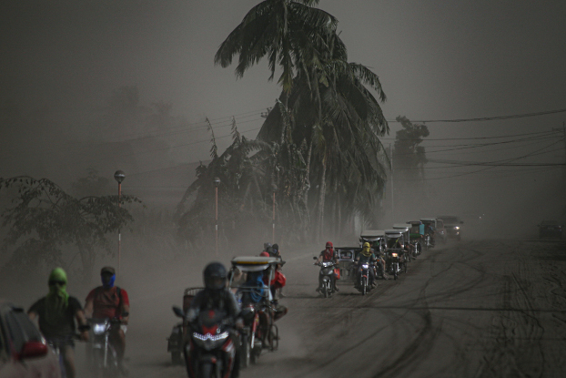 A convoy of motorcycles heads away from Agoncillo town in Batangas province to escape the ash from the Taal Volcano eruption, Jan. 13, 2020. [Jojo Riñoza/BenarNews]