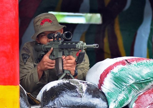 An officer guards the Indonesian Mobile Brigade’s headquarters in Poso, Central Sulawesi, a day after suspected militants shot dead three policemen in the area, Dec. 21, 2012