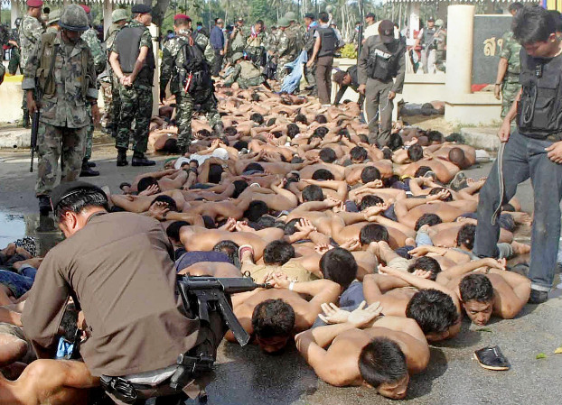 Demonstrators lie on the pavement after their arrest oustide Tak Bai police station in Narathiwat province, Thailand, Oct. 25, 2004.