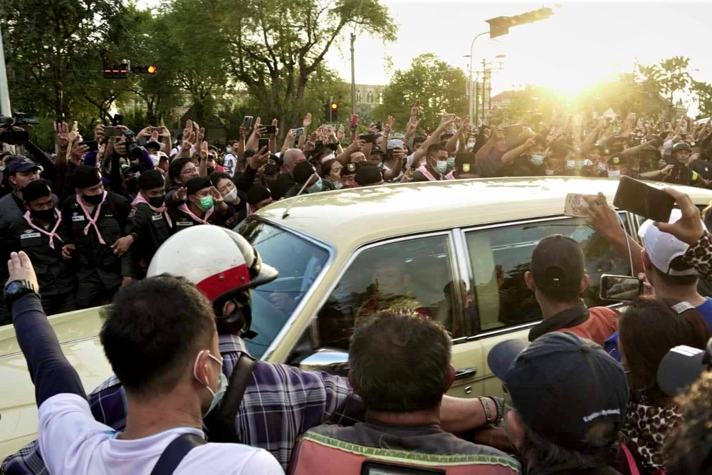Pro-democracy protesters surround a car carrying Queen Suthida and her stepson, Prince Dipangkorn Rasmijoti, near Government House in Bangkok, Oct. 14, 2020. [Courtesy of Thiti Pleetong]