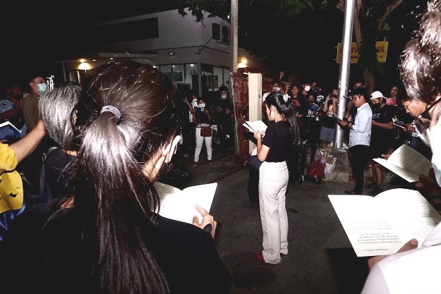 Supporters read a speech by Arnon Nampa in front of Chanasongkram police station in Bangkok while waiting for his release on Aug. 19, 2020. (BenarNews)