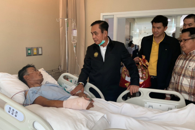 Prime Minister Prayuth Chan-o-cha visits an injured man in a hospital following a gun battle involving a Thai soldier on a shooting rampage, in Korat, Thailand, Feb. 9, 2020. [Government House/Handout via Reuters] 