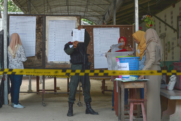Security personnel and electoral officials count votes at a polling station after polls closed in Narathiwat, a province in Thailand’s troubled Deep South, March 24, 2019. [AFP]