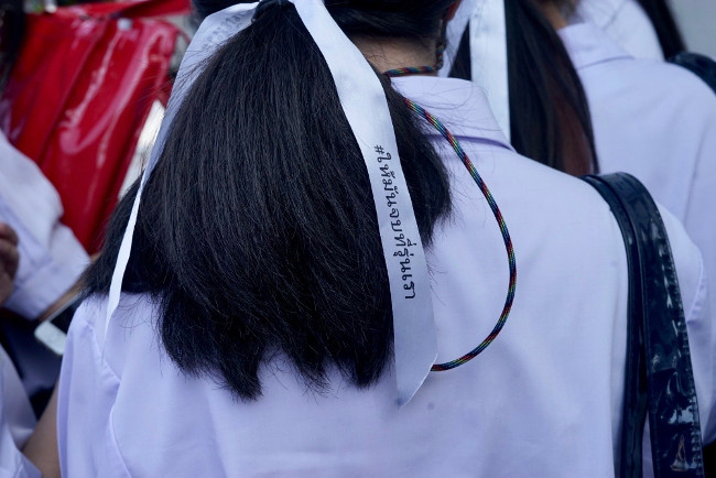 A high school student at a protest in Bangkok wears a white ribbon to symbolize freedom, Oct. 13, 2020.  