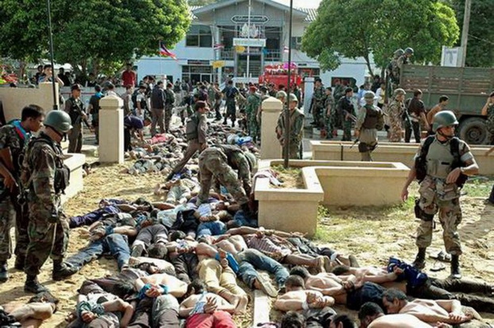 Police and soldiers stand over protesters outside the Tak Bai police station, Oct. 25, 2004. (Matahari Ismail/BenarNews)