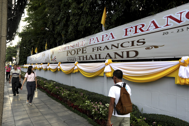 People walk past a banner welcoming Pope Francis to Bangkok, Nov. 19, 2019. [AP]