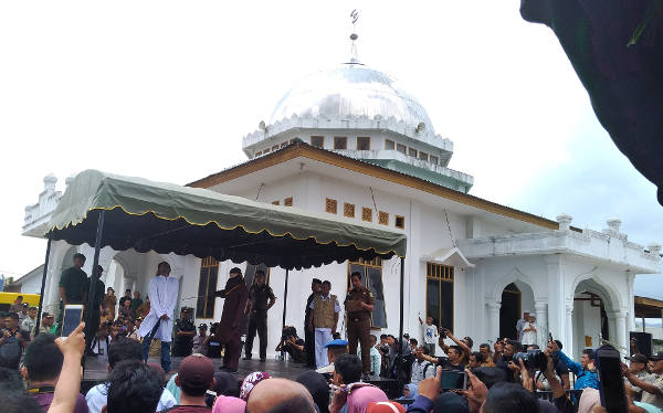 Warga mengabadikan prosesi eksekusi cambuk di halaman Masjid Babussalam di Banda Aceh, 27 Februari 2018. (Nurdin Hasan/BeritaBenar)