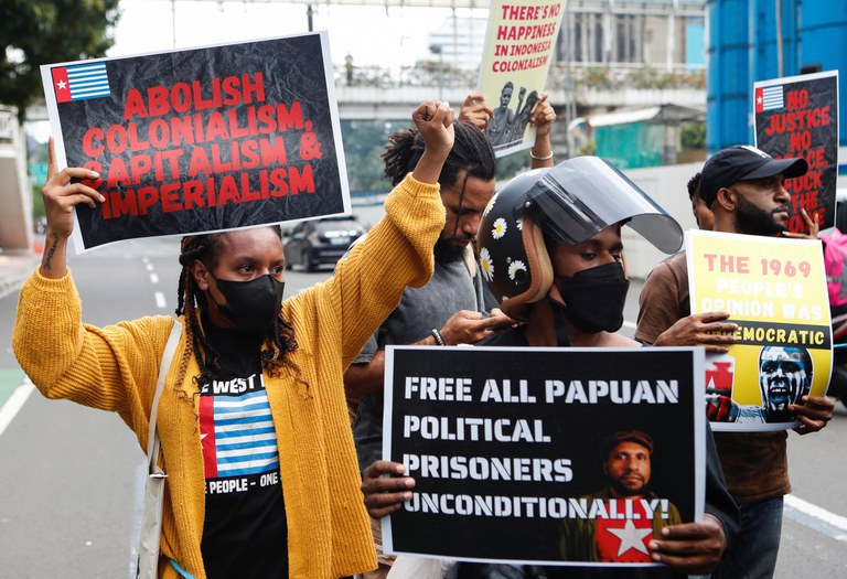 Mahasiswa dan aktivis Papua membawa poster berunjuk rasa menuntut hak menentukan nasib sendiri dan pembebasan para tahanan politik di luar gedung Perserikatan Bangsa-Bangsa di Jakarta, 19 Desember 2022. [Ajeng Dinar Ulfiana/Reuters]