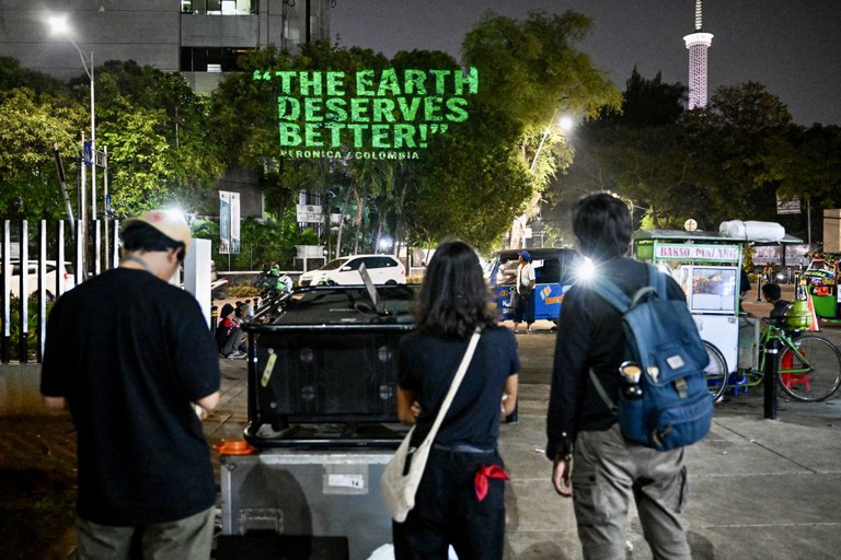 Aktivis Greenpeace memproyeksikan kampanye mereka tentang kerusakan lingkungan ke pohon di sebuah taman di Jakarta, 18 Oktober 2024. [Bay Ismoyo/AFP]