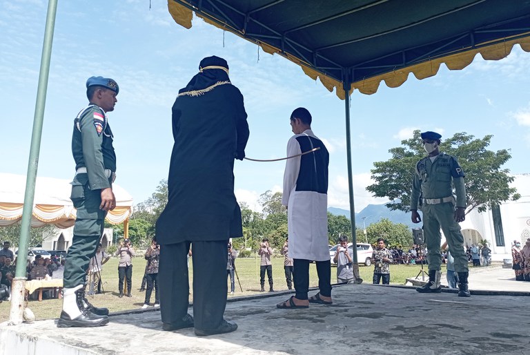 Algojo dari polisi syariah mencambuk M. Afzal di halaman Masjid Agung Al-Munawarrah Kota Jantho, Kabupaten Aceh Besar, 7 Juni 2024. Afzal dicambuk enam kali karena bermain judi online. [Nurdin Hasan/BenarNews]