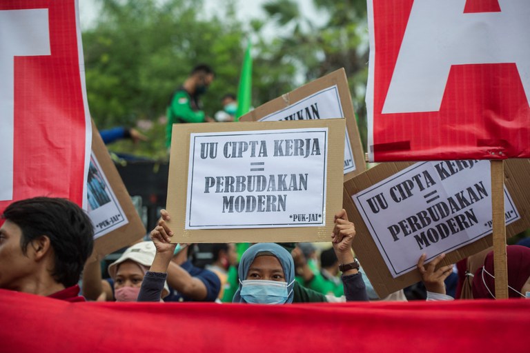 Aktivis berunjuk rasa memprotes disahkannya Undang-Undang Cipta Kerja atau “Omnibus Law” oleh DPR karena dinilai tidak mengindahkan hak-hak buruh dan dampak atas lingkungan demi investasi, di Surabaya, 19 November 2020. [Juni Kriswanto/AFP]
