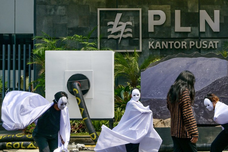 Aktivis lingkungan ikut serta dalam aksi teatrikal dan membentangkan spanduk bertuliskan “PLN, setop kecanduan batu bara” untuk memprotes kebijakan Perusahaan Listrik Negara (PLN) terkait batu bara dan adopsi energi surya oleh masyarakat, di Jakarta, 26 Oktober. 2023. [Bay Ismoyo/AFP]