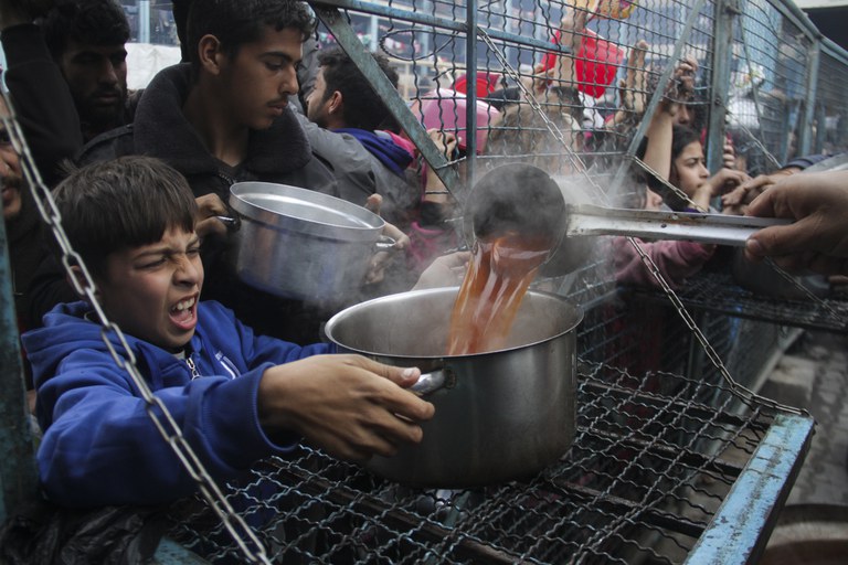 Warga Palestina antre untuk menerima makanan di kamp pengungsi Jabaliya di Jalur Gaza pada Senin, 18 Maret 2024. [Mahmoud Essa/AP Photo]