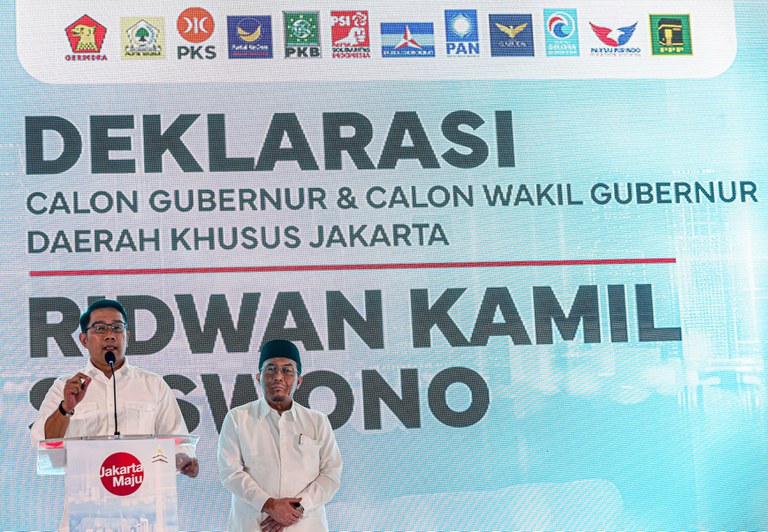 Ridwan Kamil (kiri), calon gubernur Jakarta, dan pasangannya Suswono (kanan) mendeklarasikan pencalonan mereka di panggung dengan latar belakang yang menampilkan logo 12 partai politik yang mendukung mereka, di Jakarta pada 19 Agustus 2024. [Eko Siswono Toyudho/BenarNews]