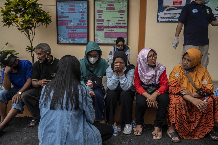 Para keluarga korban menunggu di luar sebuah rumah sakit di Malang, Jawa Timur untuk mendapatkan konfirmasi tentang nasib keluarga mereka yang menjadi korban kerusuhan di Stadion Kanjuruhan, 2 Oktober 2022. [Juni Kriswanto/AFP]