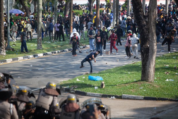 Dalam foto yang diambil pada 11 September 2023 ini, pengunjuk rasa melemparkan batu ke arah polisi saat berdemonstrasi di kantor Badan Usaha Batam di Provinsi Kepulauan Riau menentang rencana pemerintah untuk mengembangkan Pulau Rempang menjadi zona ekonomi yang didanai China yang akan menggusur sekitar 7.500 warga lokal. [Andaru/AFP ]