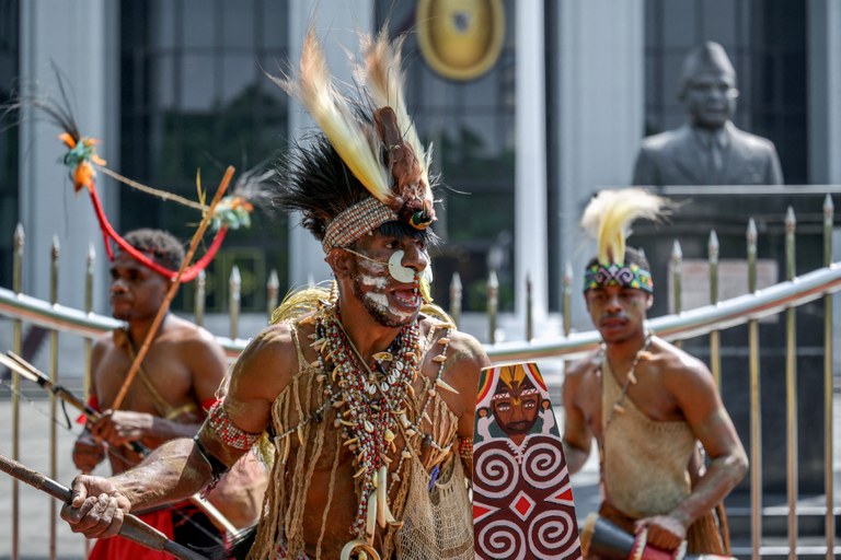 Perwakilan suku adat Papua, Awyu dan Moi, menari dan melakukan ritual di depan gedung Mahkamah Agung di Jakarta pada 27 Mei 2024, dalam sebuah protes bersama aktivis lingkungan, menyerukan agar Mahkamah Agung mencabut izin perusahaan kelapa sawit yang akan beroperasi di tanah Papua, yang berpotensi membuka dan menghancurkan sekitar 300 kilometer persegi hutan adat di wilayah itu. [Bay Ismoyo/AFP]