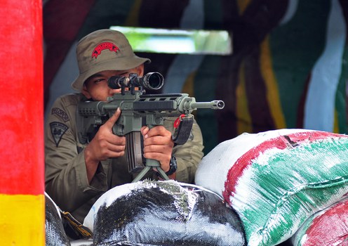 Seorang petugas Brimob melakukan penjagaan di markas kepolisia di Poso, Sulawesi Tengah, sehari setelah tersangka militan menembak mati tiga polisi di daerah tersebut, 21 Desember 2012.