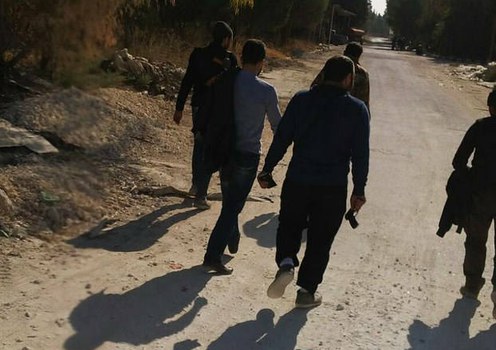Seorang pria yang juga ayah dari seorang kombatan ISIS berjalan kaki bersama beberapa orang yang menolongnya mencari anaknya, setelah mobil mereka mogok di dekat Aleppo, Suriah, pada bulan Desember 2013. 