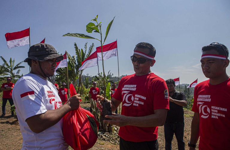 Komandan Operasi Madago Raya, Kombes. Pol. Boy FS Samola (kanan) memberikan secara simbolis bantuan sembako dan bibit tanaman kepada salah satu eks-narapidana terorisme seusai pembentangan bendera Merah Putih di kaki Gunung Biru, Desa Pantangolemba, Kecamatan Poso Pesisir Selatan, Poso, Sulawesi Tengah, Sulawesi Tengah, Jumat, 16 Agustus 2024. [Taufan Bustan/BenarNews]