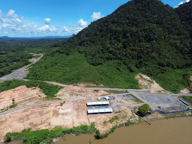 Bangunan semi permanen dengan pembangunan jalan di belakangnya, ekskavator dan area terbuka terlihat di Tugu Lima, di Kalimantan Utara, 5 Juni 2024. [Norjannah/BenarNews]