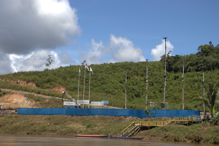 Dari kejauhan tampak plang nama PT Kayan Hydro Energy dan lima tiang yang menyimbolkan lima bendungan – atau Tugu Lima -- yang menandakan kehadiran dan rencana pembangunan dam di sepanjang Sungai Kayan, di dekat desa Long Peso, Provinsi Kalimantan Utara, 5 Juni 2024. [Norjannah/BenarNews]