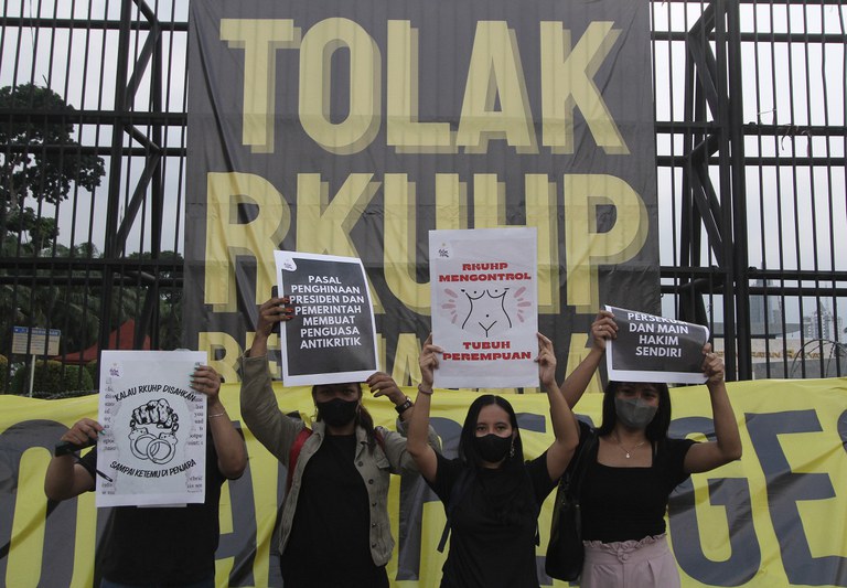 Sejumlah aktivis berunjuk rasa dengan mengacungkan poster berisi tuntutan mereka di luar Gedung DPR di Jakarta, 5 Desember 2022. [Eko Siswono Toyudho/BenarNews]