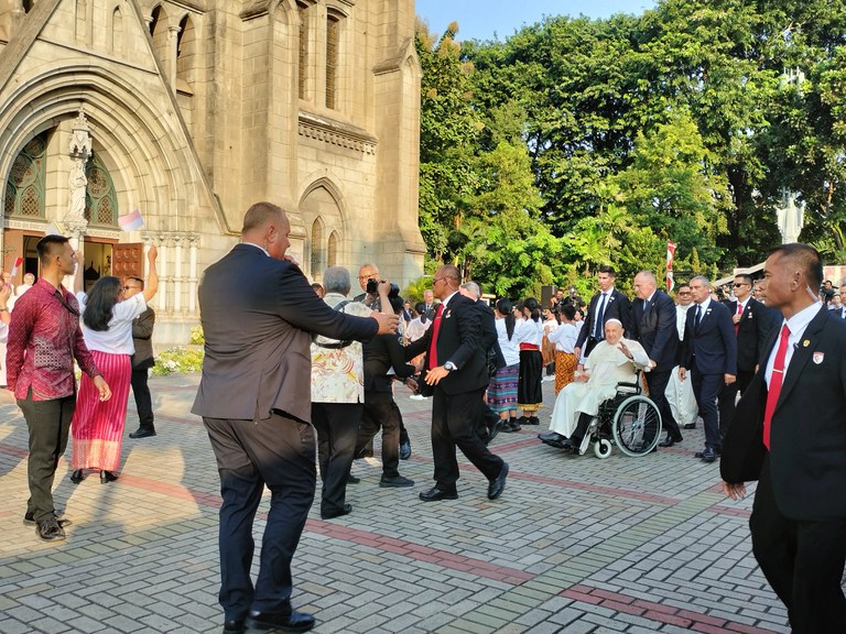 Paus Fransiskus tampak melambaikan tangan ketika tiba di Gereja Katedral Jakarta, 4 September 2024. Ia berkeliling menyapa anak-anak dan sejumlah masyarakat yang menunggunya sejak siang. (Tria Dianti/BenarNews)