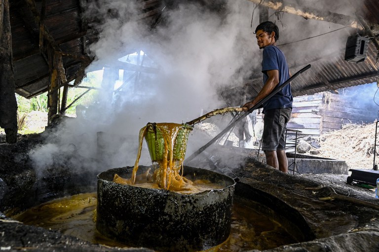 Seorang warga mengolah tebu untuk menghasilkan gula merah di industri rumah tangga di Ketol, Aceh Tengah, 19 September 2022. [Chaideer Mahyuddin/AFP]