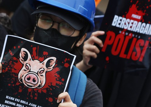 Seorang demonstrator membawa poster bergambar kepala babi dalam aksi di depan gedung DPR, Jakarta, Kamis, 27 Maret 2025, mengecam ancaman terhadap kebebasan pers setelah staf media Tempo menerima paket berisi kepala babi tanpa identitas pengirim, yang diduga sebagai upaya intimidasi untuk membungkam kebebasan berpendapat.