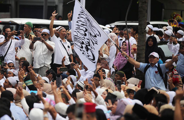 Seorang pendukung calon presiden Prabowo Subianto membawa bendera bertuliskan kalimat Tauhid saat acara syukuran kemenangan di Jakarta, 19 April 2019. (Keisyah Aprilia/BeritaBenar)