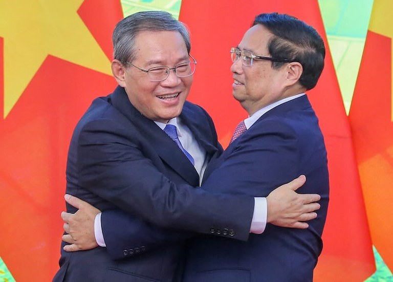 Perdana Menteri Vietnam Pham Minh Chinh, kanan, dan Perdana Menteri Tiongkok Li Qiang berpelukan dalam pertemuan di Hanoi pada 13 Oktober 2024. [Luong Thai Linh/Pool via AFP]