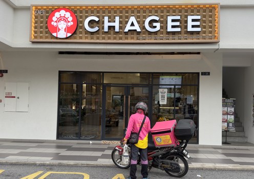 Seorang penunggang e-hailing mengambil produk Chagee yang ditempah pelanggan di sebuah cawangan rangkaian kafe teh China itu di Kajang, Selangor, 21 Mac 2025.