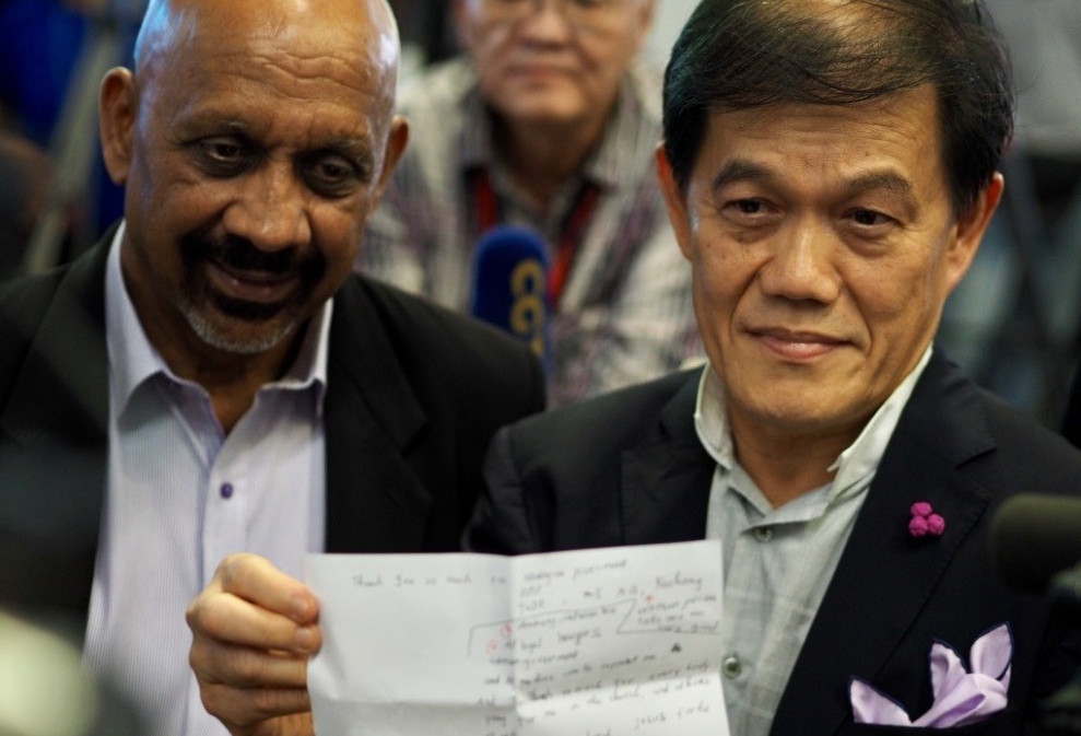 Hisyam Teh Poh Teik menunjukkan surat yang ditulis oleh Doan, sambil disaksikan rakannya Narin Singh pada sidang berita di Lapangan Terbang Antarabangsa Kuala Lumpur, Malaysia. 3 Mei 2019. 