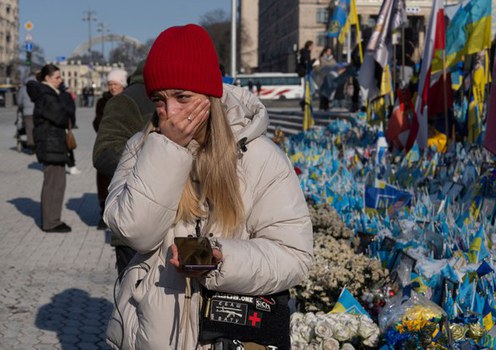 Seorang wanita menangis di pekarangan tugu peringatan tentera Ukraine yang terkorban di Dataran Kemerdekaan, Kyiv, 24 Februari 2025.