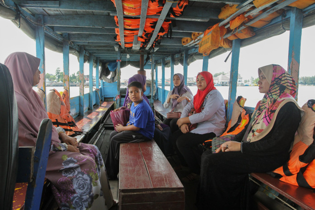 ชาวมาเลเซียนั่งเรือข้ามฟากจากฝั่งจากด่านตรวจคนเข้าเมืองฝั่งกลันตันมายังตลาดตากใบ วันที่ 26 ก.ค. 2561 (มารียัม อัฮหมัด/เบนาร์นิวส์)