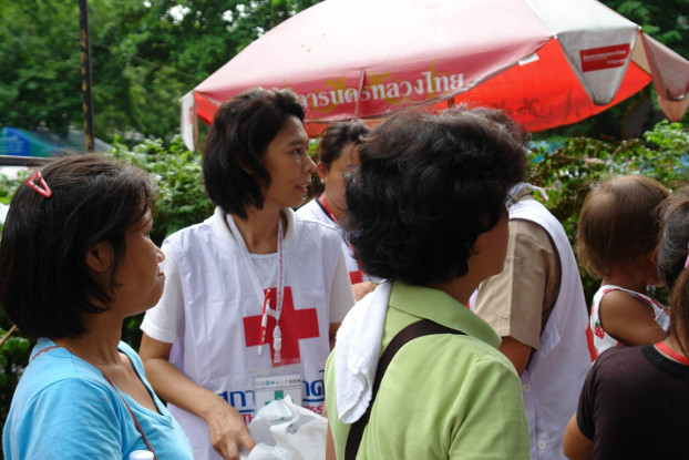 สมาชิกสภากาชาดไทยแจกอาหารและอุปกรณ์การแพทย์แก่กลุ่มผู้ประท้วง ที่วัดปทุมวนาราม ในกรุงเทพฯ สองวันก่อนที่อาสาสมัครและผู้ประท้วงถูกยิง ภาพเมื่อวันที่ 17 พฤษภาคม 2553 (ภิมุข รักขนาม/เบนาร์นิวส์)