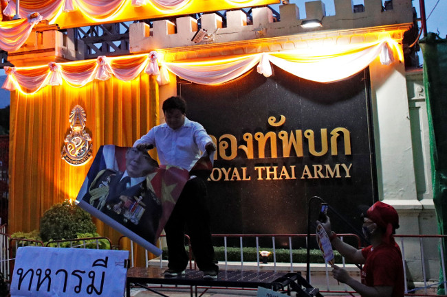 นักเคลื่อนไหวต่อต้านรัฐบาลฉีกรูปพลเอก อภิรัชต์ คงสมพงษ์ ระหว่างการประท้วง หน้ากองทัพบก กรุงเทพฯ วันที่ 20 กรกฎาคม 2563 