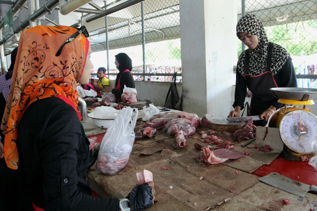 หญิงไทยมุสลิมขณะซื้อเนื้อวัวในตลาด ปัตตานี เตรียมพร้อมสำหรับการถือศีลอด วันที่ 17 พฤษภาคม 2561 (มารียัม อัฮหมัด/เบนาร์นิวส์)